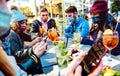 Millenial people using mobile smart phones at cocktail bar - New normal lifestyle concept with friends on contact tracing app