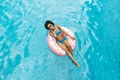 Millennial African American girl in sexy swimwear floating on donut ring at pool Royalty Free Stock Photo