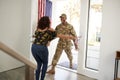 Millennial African American  male soldier returning home into the arms open of his wife, close up Royalty Free Stock Photo