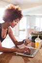 Millennial African American woman checking fitness app on watch and laptop after workout, vertical Royalty Free Stock Photo