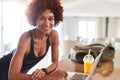 Millennial African American woman checking fitness data on laptop after gym smiling to camera Royalty Free Stock Photo