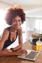 Millennial African American woman checking fitness data on laptop smiling to camera, vertical Royalty Free Stock Photo