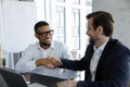 Millennial African and Caucasian businessmen handshaking accomplish meeting feel satisfied Royalty Free Stock Photo