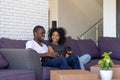 Millennial african couple sitting resting on couch on moving day