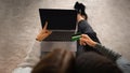 Millennial arab guy, european lady watch video on laptop with empty screen, use credit card, sit on floor Royalty Free Stock Photo