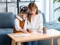 Millennial Asian cheerful happy young beautiful female teenager mother nanny babysitter sitting smiling holding color pencils Royalty Free Stock Photo