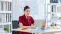 Millennial Asian happy cheerful pretty businesswoman secretary employee sitting smiling enjoy working online typing laptop Royalty Free Stock Photo