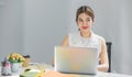 Millennial Asian happy cheerful pretty businesswoman secretary employee sitting smiling enjoy working online typing laptop Royalty Free Stock Photo