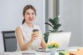 Millennial Asian happy cheerful pretty businesswoman secretary employee sitting smiling enjoy working online typing laptop Royalty Free Stock Photo