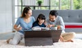 Millennial Asian happy family father and mother sitting on cozy carpet floor smiling helping teaching little young girl daughter Royalty Free Stock Photo