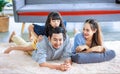 Millennial Asian lovely happy family father mother laying down on carpet floor while young daughter girl sitting piggy back on dad Royalty Free Stock Photo