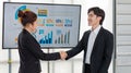 Millennial Asian professional successful male businessman and female businesswoman in formal suit standing smiling shaking hands Royalty Free Stock Photo