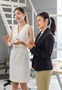 Millennial Asian professional successful two businesswomen team in formal business suit standing smiling clapping hands applauding Royalty Free Stock Photo