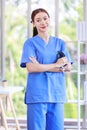 Millennial Asian young beautiful professional successful female internship nurse in blue clinical uniform holding stethoscope in