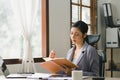 The millennial Asian young businesswoman is making notes for a business plan on her notebook, focusing on business Royalty Free Stock Photo