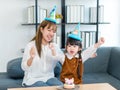 Millennial Asian young female teenager mother nanny babysitter wearing tall hat sitting together with little cute preschooler Royalty Free Stock Photo