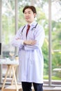 Millennial Asian young handsome professional successful male general doctor in white laboratory coat clinical uniform with Royalty Free Stock Photo