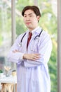 Millennial Asian young handsome professional successful male general doctor in white laboratory coat clinical uniform with Royalty Free Stock Photo