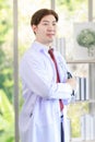 Millennial Asian young handsome professional successful male general doctor in white laboratory coat clinical uniform with Royalty Free Stock Photo