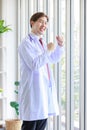 Millennial Asian young handsome professional successful male general doctor in white laboratory coat clinical uniform with Royalty Free Stock Photo