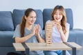 Millennial Asian young happy cheerful joyful female lesbian LGBTQ lover couple sitting smiling laughing together on carpet floor Royalty Free Stock Photo