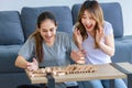 Millennial Asian young happy cheerful joyful female lesbian LGBTQ lover couple sitting smiling laughing together on carpet floor Royalty Free Stock Photo