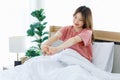 Millennial Asian young happy cheerful lazy sleepy female teenager sitting laying smiling on pillow under thick warm blanket on