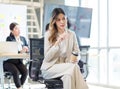 Millennial Asian young professional successful female businesswoman in formal suit high heels sitting smiling posing on chair Royalty Free Stock Photo