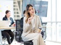 Millennial Asian young professional successful female businesswoman in formal suit high heels sitting smiling posing on chair Royalty Free Stock Photo