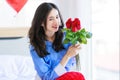 Millennial Asian young romantic cheerful female girlfriend sitting on bed in bedroom decorate with pink heart shape balloon Royalty Free Stock Photo