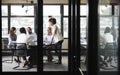 Millennial black businesswoman stands addressing colleagues at a meeting, seen through glass wall Royalty Free Stock Photo