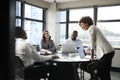 Millennial black businesswoman stands listening to corporate colleagues at a meeting, close up Royalty Free Stock Photo