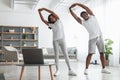 Young black couple doing side bend exercise using pc Royalty Free Stock Photo