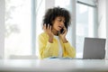 Millennial black female manager indignantly talking on a mobile phone at the workplace in the office, empty space Royalty Free Stock Photo