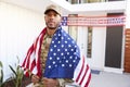 Millennial African American  soldier with US flag draped over his shoulders, looking to camera, close up Royalty Free Stock Photo