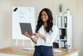 Millennial black woman with laptop working onine, having web conference or meeting at modern office