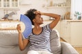 Millennial black woman suffer from heatstroke, hot temperature at home use paper fan for fresh air