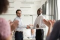 Millennial boss handshake black colleague congratulating with promotion