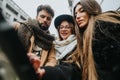 Millennial business teammates working on digital tablet in snowy urban setting. Royalty Free Stock Photo