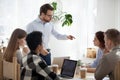 Millennial businessman stand leading meeting scolding colleague