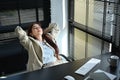 Millennial businesswoman relaxing on office chair with her eyes closed and her hands behind her head Royalty Free Stock Photo