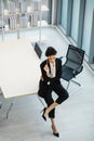 Millennial Caucasian successful young curious thoughtful businesswoman in formal suit holding pencil sitting on table thinking Royalty Free Stock Photo