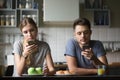 Millennial couple obsessed with smartphones ignoring each other