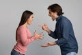 Millennial couple quarreling, shouting and blaming each other over light background Royalty Free Stock Photo