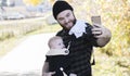 Millennial Dad with Baby in Carrier Outside Walking & Taking Sel Royalty Free Stock Photo