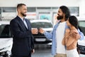 Millennial eastern spouses buying new automobile at showroom store Royalty Free Stock Photo