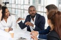 Black millennial boss leading corporate team during briefing in boardroom