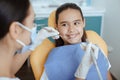 Millennial female doctor in protective mask and glove holds medical instrument and checks oral cavity