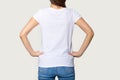Millennial female wearing white t-shirt standing turning back to camera