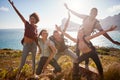 Millennial friends on a hiking trip reach the summit and have fun posing for photos